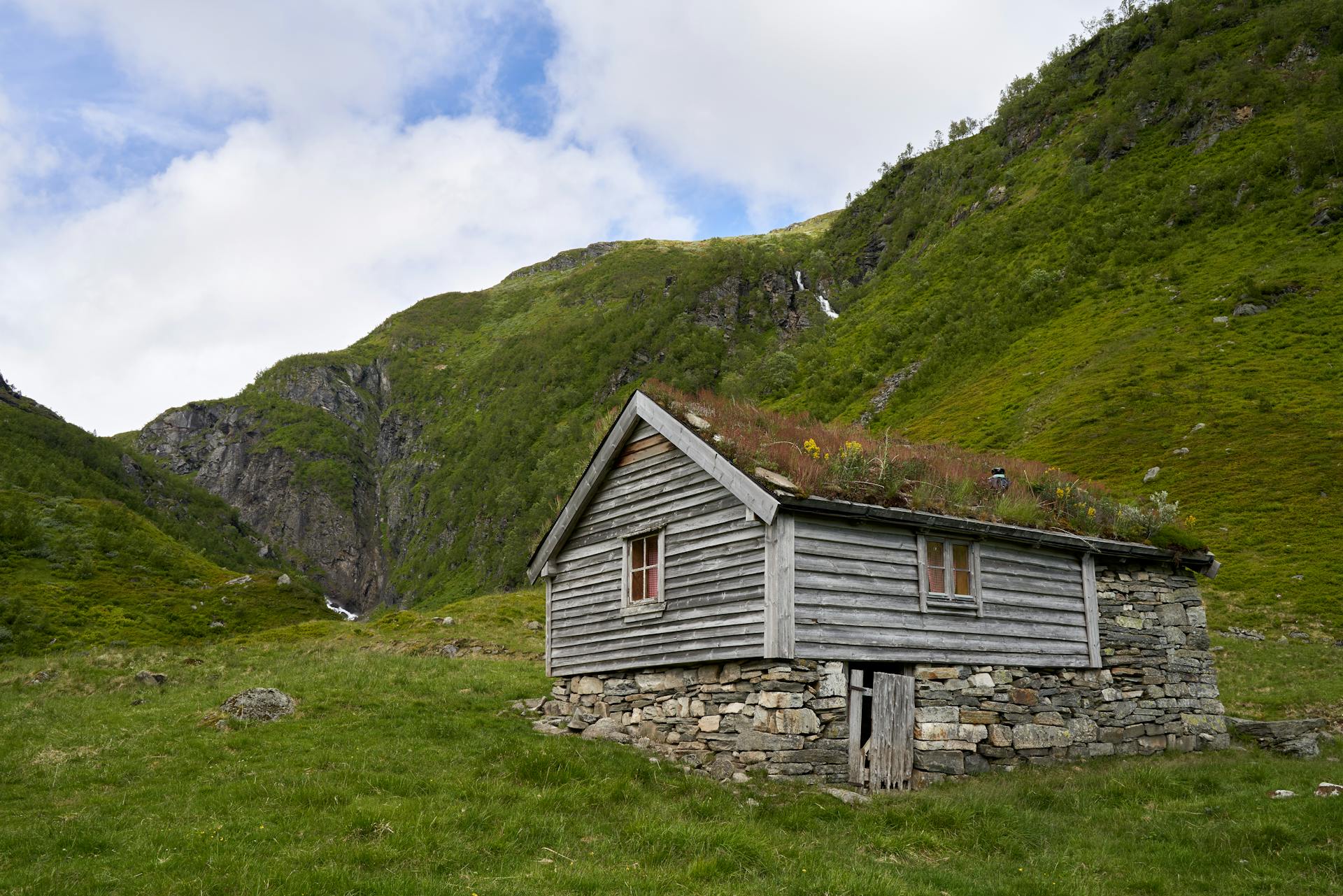 Photo by Barnabas Davoti: https://www.pexels.com/photo/brown-wooden-house-on-grass-near-mountain-8841881/